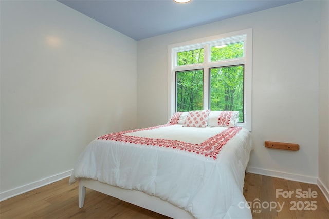 bedroom featuring baseboards and wood finished floors