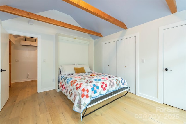 bedroom featuring light wood-style flooring, a closet, a wall mounted AC, and baseboards