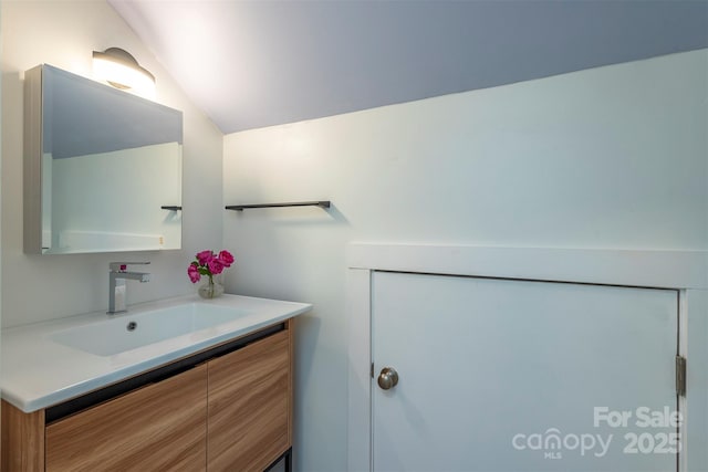 bathroom featuring vanity and vaulted ceiling