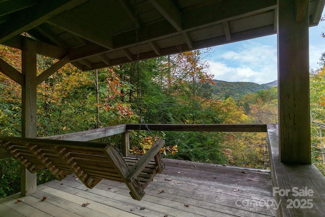 deck with a mountain view and a view of trees