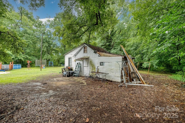 5240 Old Monroe Rd, Indian Trail, NC 28079 - rear view of property featuring an outbuilding, a yard, and view of scattered trees