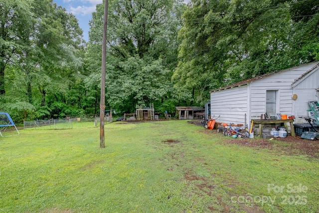 5240 Old Monroe Rd, Indian Trail, NC 28079 - view of yard featuring a playground, an outdoor structure, and view of wooded area