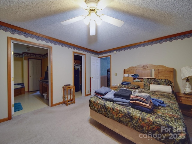 bedroom featuring carpet flooring, a textured ceiling, and a walk in closet