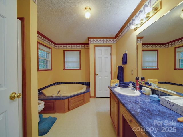 full bath featuring toilet, vanity, a textured ceiling, and a bath