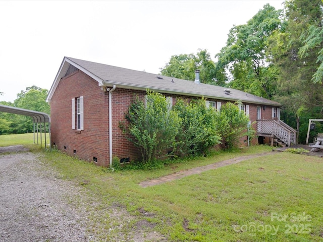 exterior space featuring a yard, driveway, brick siding, and crawl space