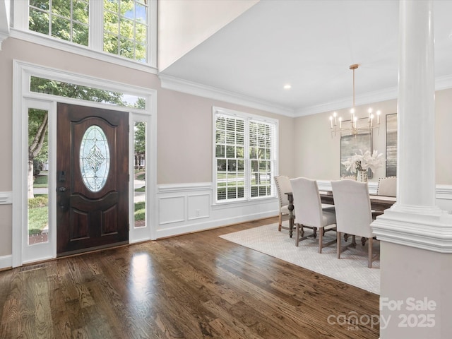 13029 Whisper Creek Dr, Charlotte, NC 28277 - entryway featuring a chandelier, wood finished floors, crown molding, wainscoting, and a decorative wall