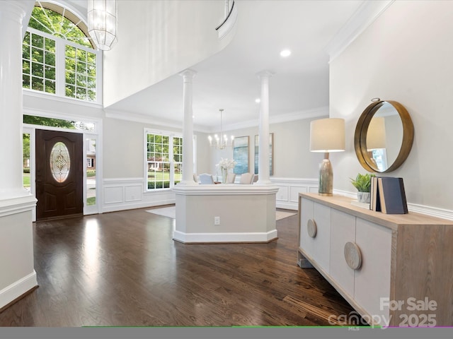 13029 Whisper Creek Dr, Charlotte, NC 28277 - foyer featuring a chandelier, decorative columns, ornamental molding, a decorative wall, and dark wood-type flooring