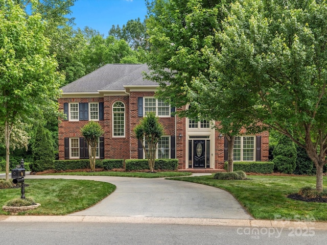 13029 Whisper Creek Dr, Charlotte, NC 28277 - colonial home with a front lawn, brick siding, curved driveway, and a shingled roof