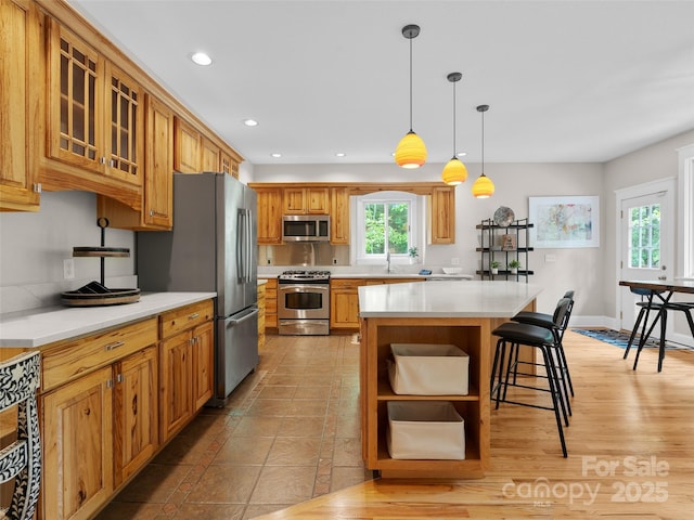 33 Village Pointe Ln, Asheville, NC 28803 - kitchen with appliances with stainless steel finishes, a breakfast bar area, recessed lighting, light countertops, and glass insert cabinets