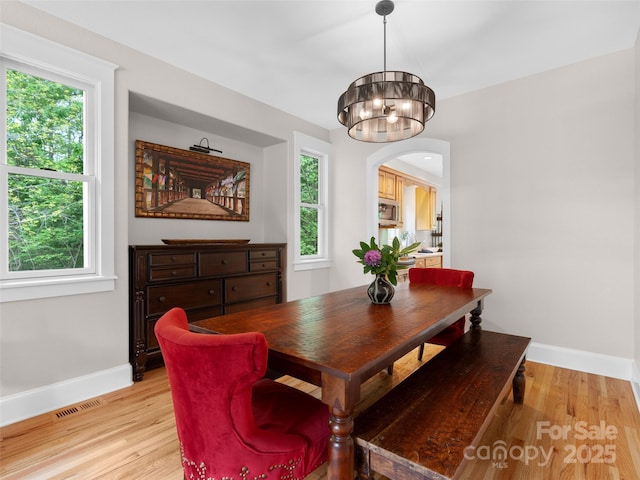 33 Village Pointe Ln, Asheville, NC 28803 - dining room with a chandelier, baseboards, light wood-style floors, and arched walkways