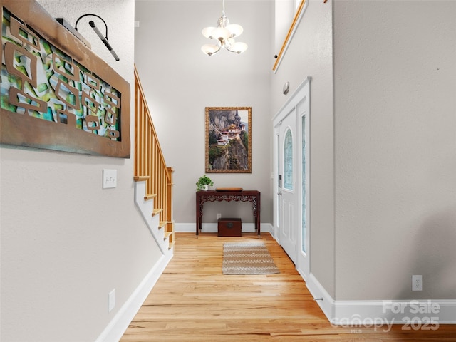 33 Village Pointe Ln, Asheville, NC 28803 - foyer featuring light wood-style floors, a chandelier, stairway, baseboards, and a high ceiling