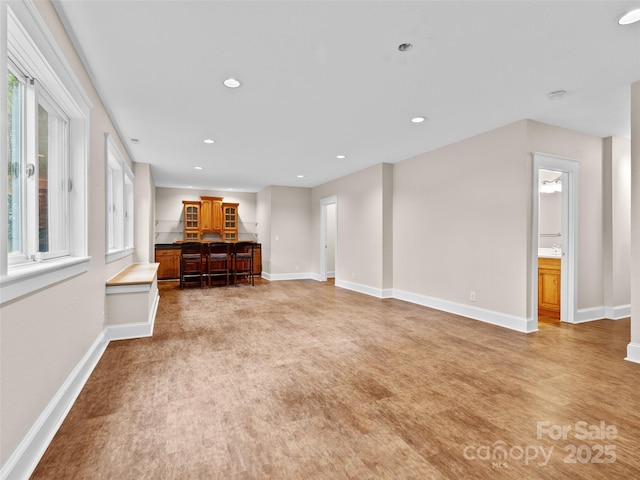33 Village Pointe Ln, Asheville, NC 28803 - unfurnished living room with baseboards, recessed lighting, bar, and light wood-type flooring