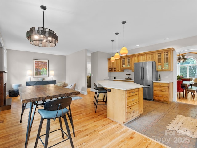 33 Village Pointe Ln, Asheville, NC 28803 - kitchen with freestanding refrigerator, a center island, light countertops, light wood-style flooring, and glass insert cabinets