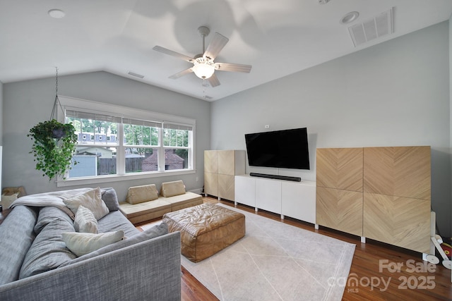 living room featuring ceiling fan, vaulted ceiling, and wood finished floors
