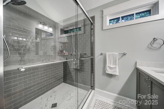 full bath featuring a stall shower, baseboards, and lofted ceiling