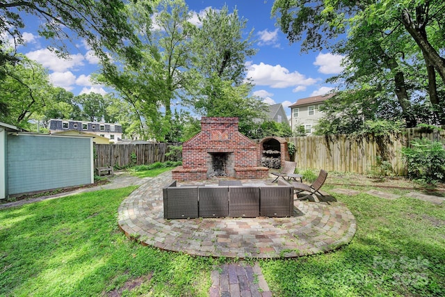 view of yard with a patio area and an outdoor living space with a fireplace
