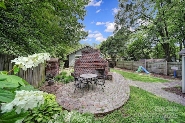 fenced backyard featuring a patio area, an outdoor brick fireplace, and outdoor dining space