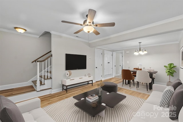 living area with crown molding, stairs, ceiling fan with notable chandelier, and light wood-style flooring