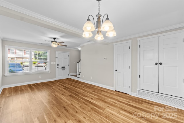 interior space with light wood finished floors, ornamental molding, baseboards, and ceiling fan with notable chandelier