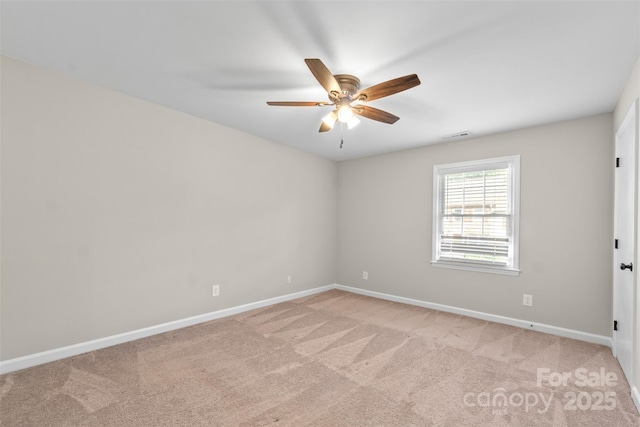 empty room featuring a ceiling fan, light carpet, baseboards, and visible vents