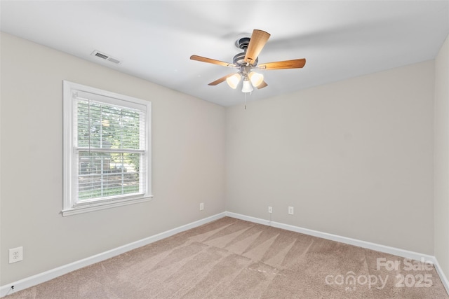 spare room with light carpet, baseboards, a ceiling fan, and visible vents
