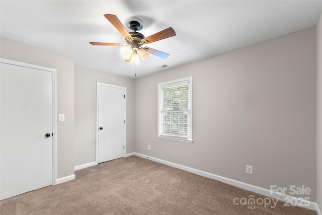 interior space with baseboards, a ceiling fan, visible vents, and carpet floors