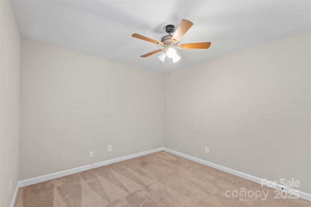 carpeted spare room with baseboards and a ceiling fan