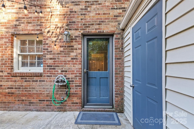 entrance to property featuring brick siding