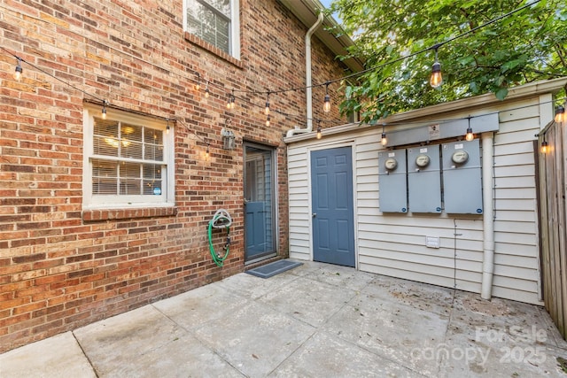 property entrance with a patio area and brick siding