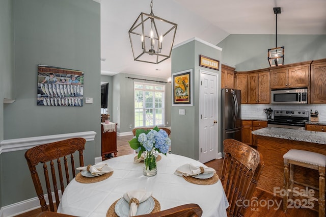 319 Beacon Hills Dr, Gastonia, NC 28056 - dining area with vaulted ceiling, wood finished floors, and a chandelier