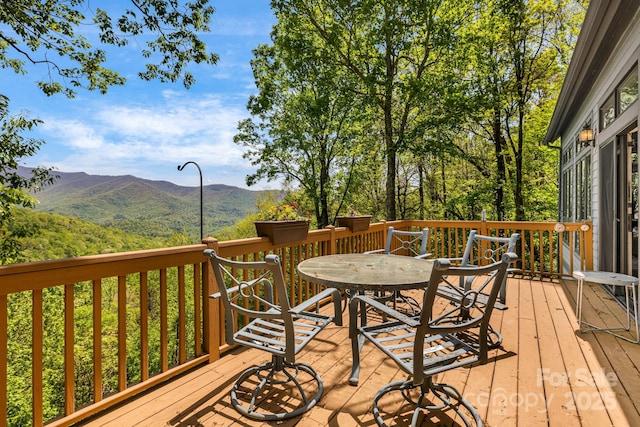 wooden terrace featuring outdoor dining area and a mountain view