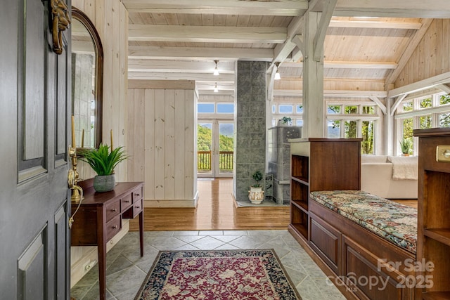 foyer entrance featuring wood ceiling, light tile patterned floors, and wood walls