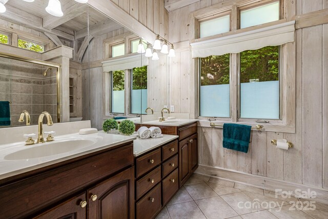 bathroom featuring wooden walls, tile patterned floors, a shower stall, double vanity, and beamed ceiling