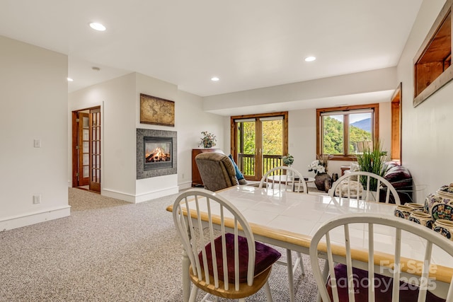 carpeted dining space featuring recessed lighting, a multi sided fireplace, and baseboards