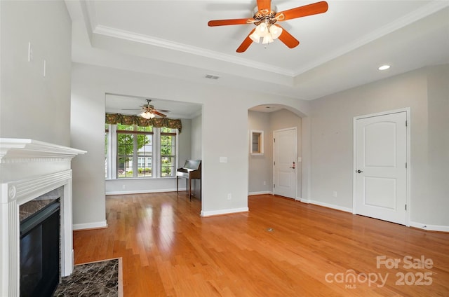 5028 Polo Gate Blvd, Charlotte, NC 28216 - unfurnished living room with a tray ceiling, arched walkways, a ceiling fan, wood finished floors, and baseboards