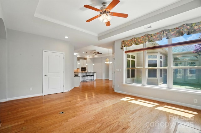 5028 Polo Gate Blvd, Charlotte, NC 28216 - unfurnished living room with a raised ceiling, light wood-type flooring, ceiling fan, baseboards, and crown molding