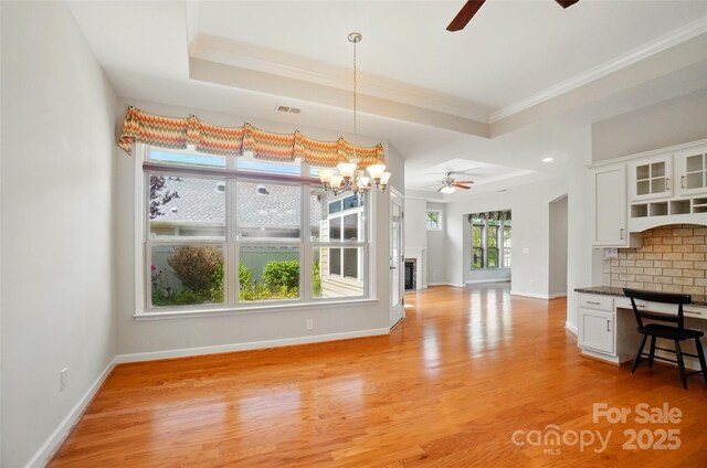 5028 Polo Gate Blvd, Charlotte, NC 28216 - unfurnished dining area with a ceiling fan, a chandelier, light wood finished floors, baseboards, and crown molding