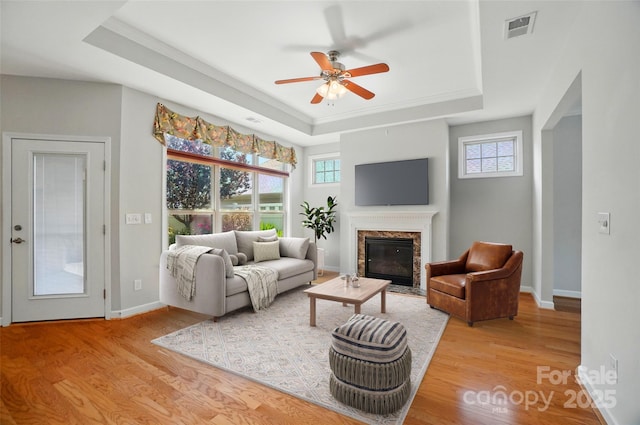 5028 Polo Gate Blvd, Charlotte, NC 28216 - living room with a raised ceiling, plenty of natural light, wood finished floors, a ceiling fan, and ornamental molding