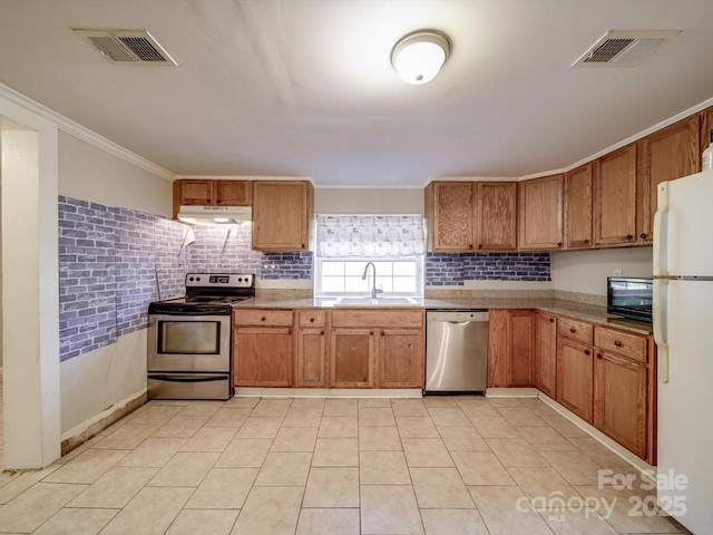 363 Sowers Rd, Linwood, NC 27299 - kitchen featuring stainless steel appliances, under cabinet range hood, a sink, brown cabinets, and crown molding