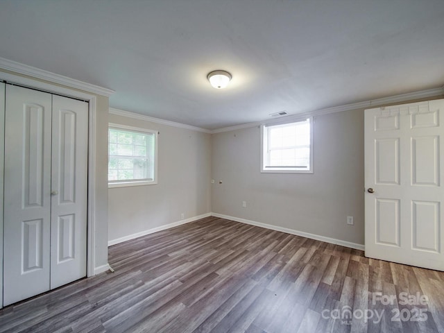 363 Sowers Rd, Linwood, NC 27299 - unfurnished bedroom featuring multiple windows, wood finished floors, crown molding, baseboards, and a closet