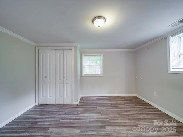 363 Sowers Rd, Linwood, NC 27299 - unfurnished bedroom featuring multiple windows, wood finished floors, crown molding, and baseboards