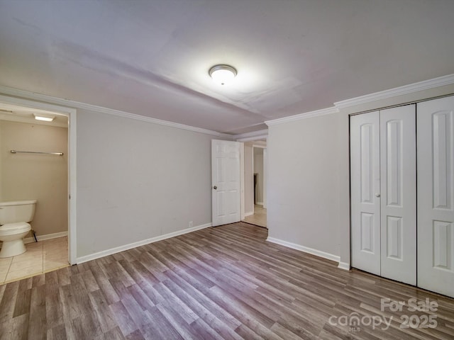 363 Sowers Rd, Linwood, NC 27299 - unfurnished bedroom with wood finished floors, a closet, baseboards, ensuite bathroom, and ornamental molding