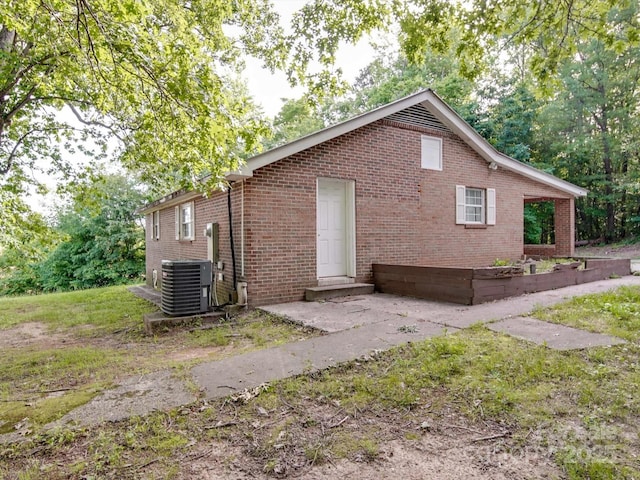 363 Sowers Rd, Linwood, NC 27299 - view of side of property with central air condition unit, brick siding, and a patio area