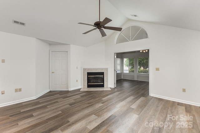 unfurnished living room with a tile fireplace, visible vents, wood finished floors, and a ceiling fan