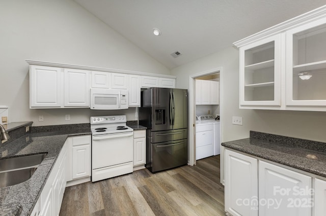 kitchen featuring a sink, separate washer and dryer, white cabinets, visible vents, and white appliances