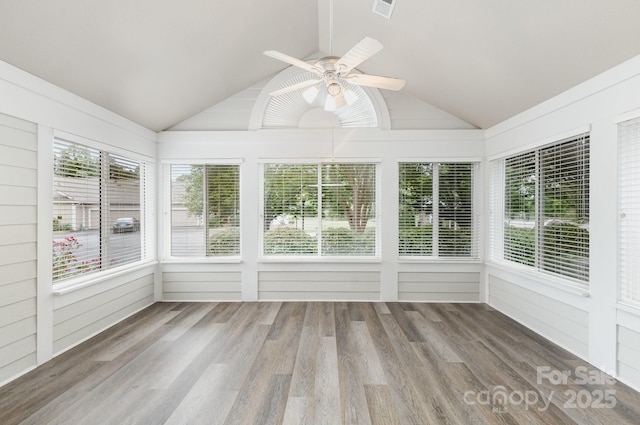 unfurnished sunroom featuring vaulted ceiling, visible vents, and wood finished floors