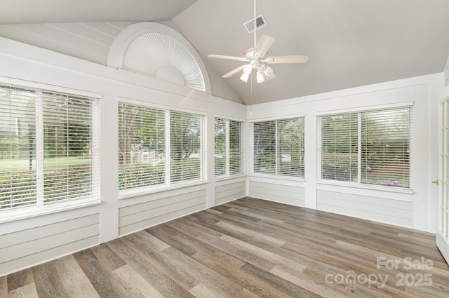 unfurnished sunroom featuring lofted ceiling, visible vents, and wood finished floors
