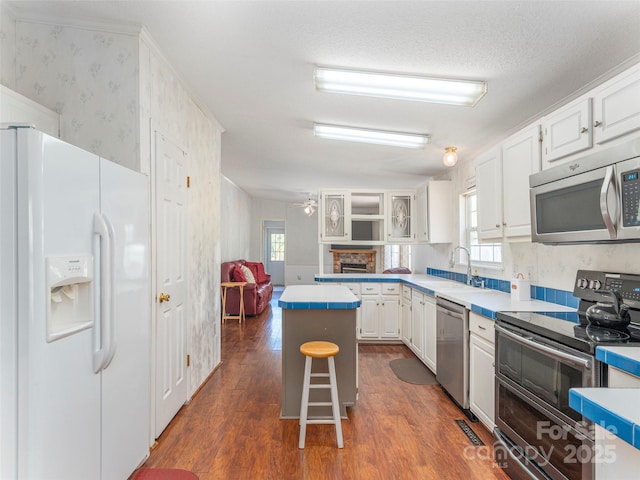 9 Redmond Dr, Alexander, NC 28701 - kitchen featuring a sink, stainless steel appliances, dark wood-style flooring, light countertops, and wallpapered walls