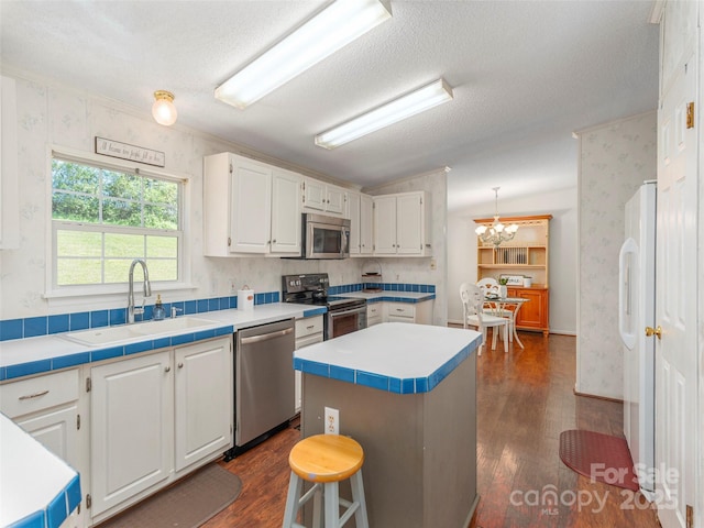 9 Redmond Dr, Alexander, NC 28701 - kitchen featuring white cabinetry, stainless steel appliances, dark wood-style floors, and a sink