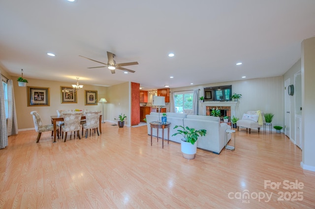 6 Chipmunk Cove Rd, Asheville, NC 28804 - living area with a brick fireplace, ceiling fan with notable chandelier, baseboards, and light wood-style floors